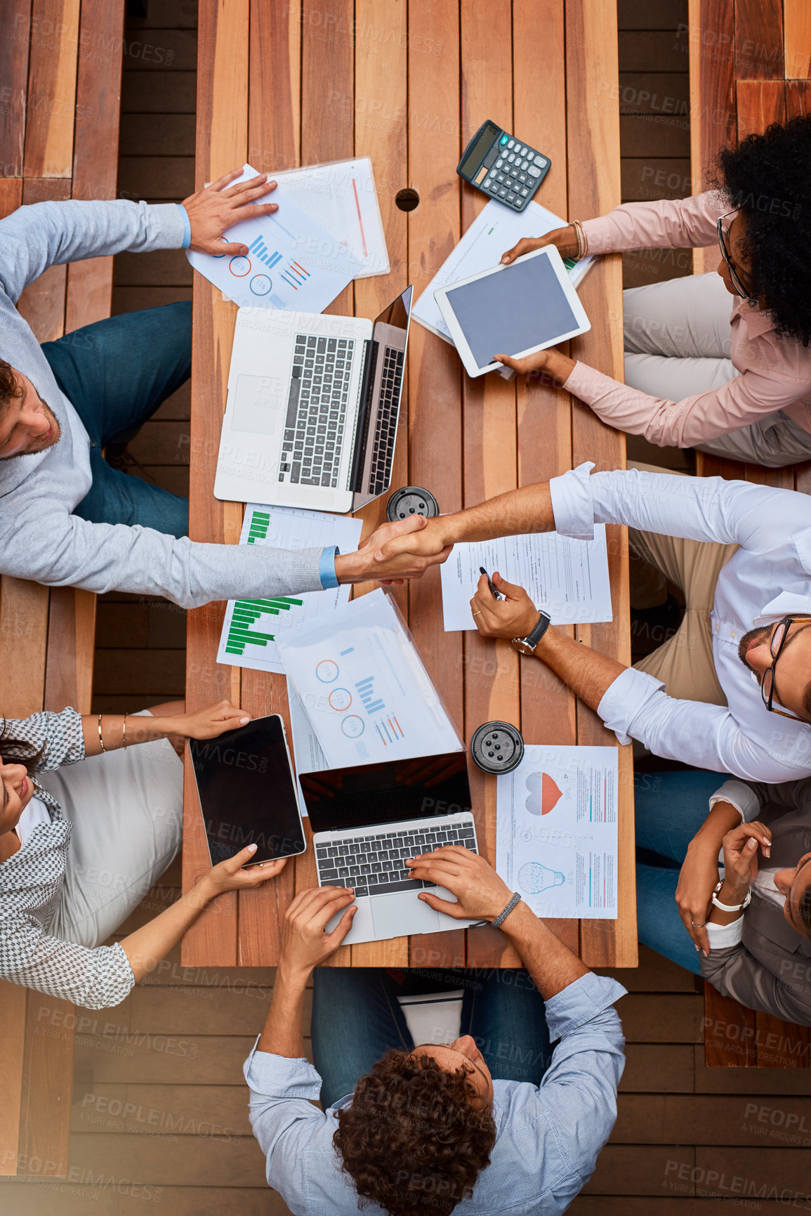 Buy stock photo High angle shot of businesspeople shaking hands during a meeting outdoors