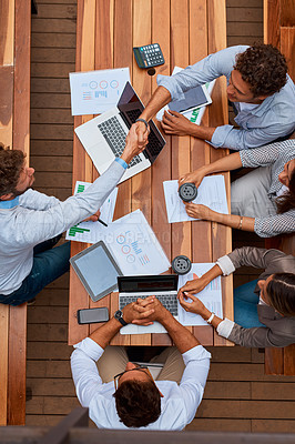 Buy stock photo High angle shot of businesspeople shaking hands during a meeting outdoors