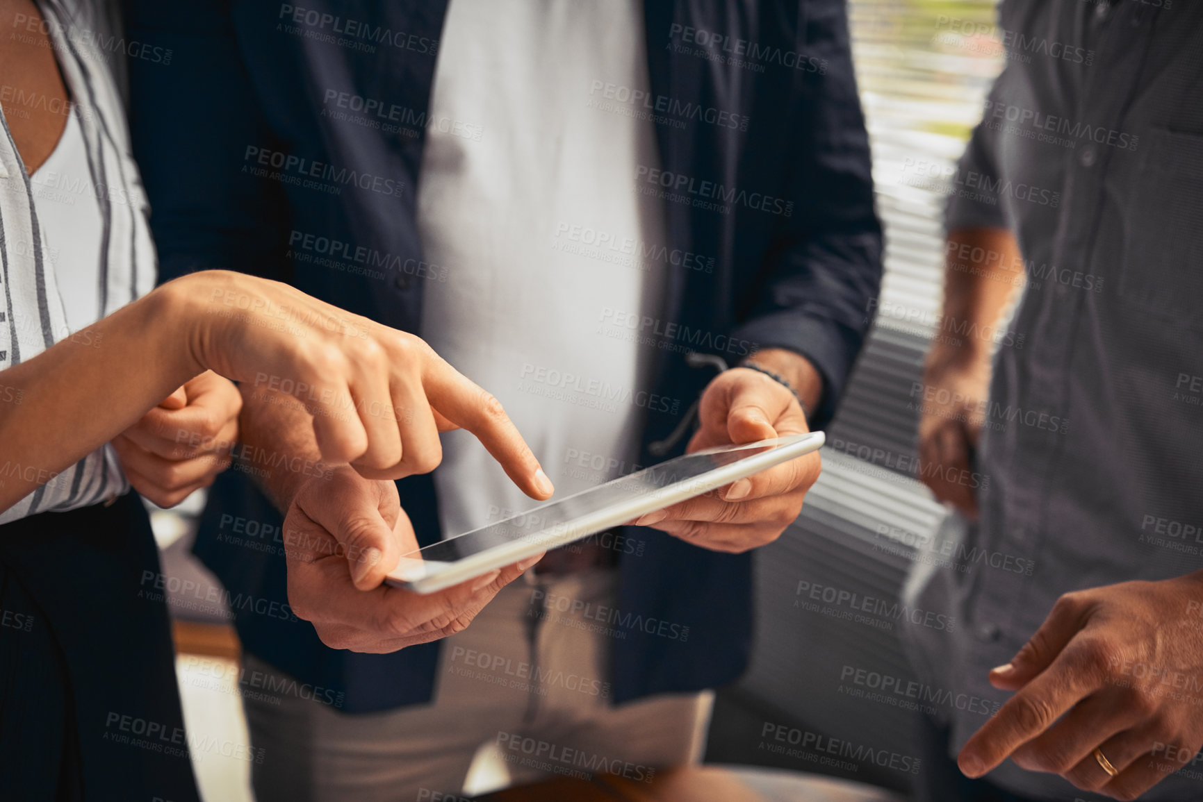 Buy stock photo Cropped shot of unrecognizable businesspeople working together and using a tablet in the office