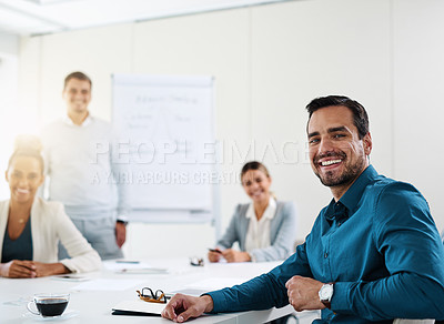 Buy stock photo Portrait of a young businessman having a meeting with his colleagues in an office