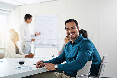 Buy stock photo Portrait of a young businessman having a meeting with his colleagues in an office