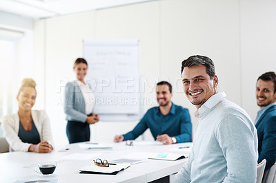 Buy stock photo Portrait of a young businessman having a meeting with his colleagues in an office