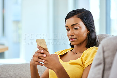 Buy stock photo Indian girl, typing and phone on sofa in home for social media scroll, internet subscription and online streaming. Gen z, serious person and smartphone on couch for text message, dating site or relax