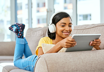 Buy stock photo Girl, happy and headphones with tablet on sofa at home on streaming platform, website and internet. Female person, woman and smile with watching movies, film and entertainment for fun and break