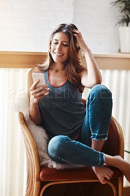 Buy stock photo Shot of an attractive young woman using her cellphone at home