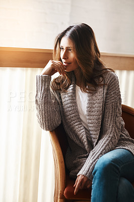 Buy stock photo Shot of an attractive young woman relaxing on a chair at home