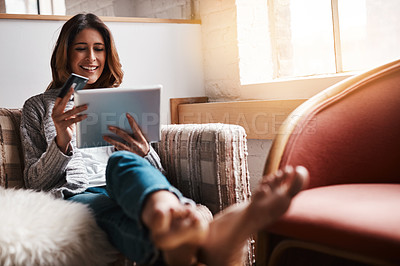 Buy stock photo Relax, tablet and credit card with an ecommerce woman sitting on a sofa in the living room of her home. Online shopping, fintech and financial banking with a young female online customer in her house