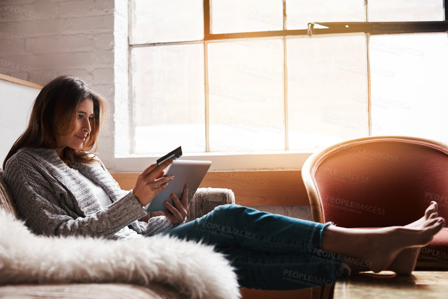 Buy stock photo Relax, tablet and credit card with a woman banking online on a sofa in the living room of her home. Ecommerce, financial freedom and shopping with a young female customer or consumer in her house