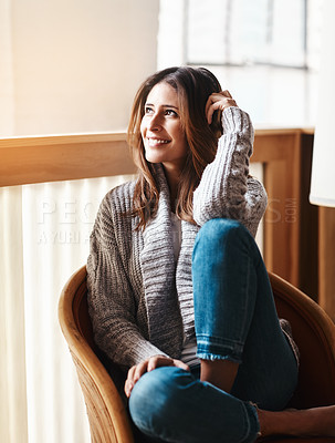 Buy stock photo Shot of an attractive young woman relaxing on a chair at home