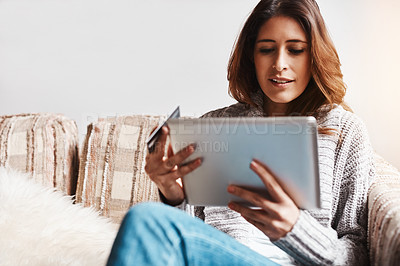 Buy stock photo Internet, tablet and credit card with an ecommerce woman on a sofa in the living room of her home. Online shopping, finance and fintech payment with a young female online customer in her house