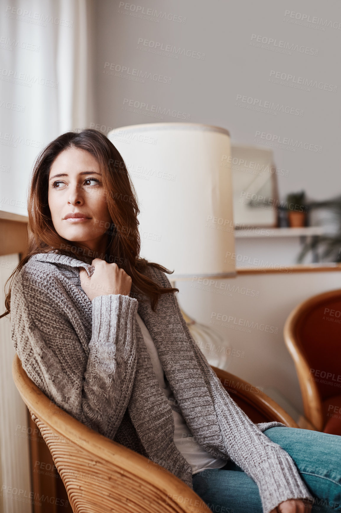 Buy stock photo Shot of an attractive young woman relaxing on a chair at home