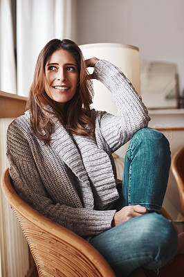 Buy stock photo Shot of an attractive young woman relaxing on a chair at home