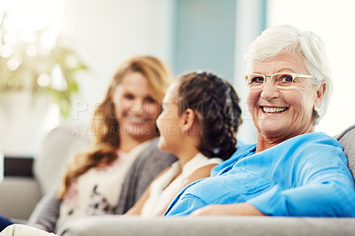 Buy stock photo Cropped portrait of a senior woman sitting on the sofa at home with her daughter and granddaughter