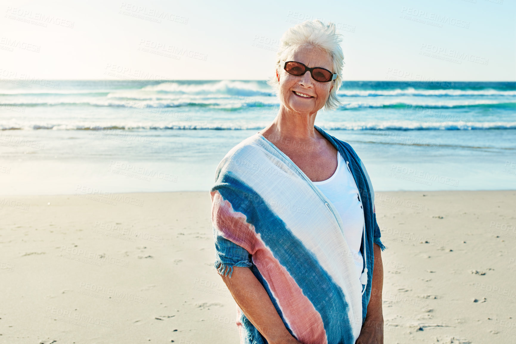 Buy stock photo Cropped portrait of a senior woman visiting the beach on a summer's day