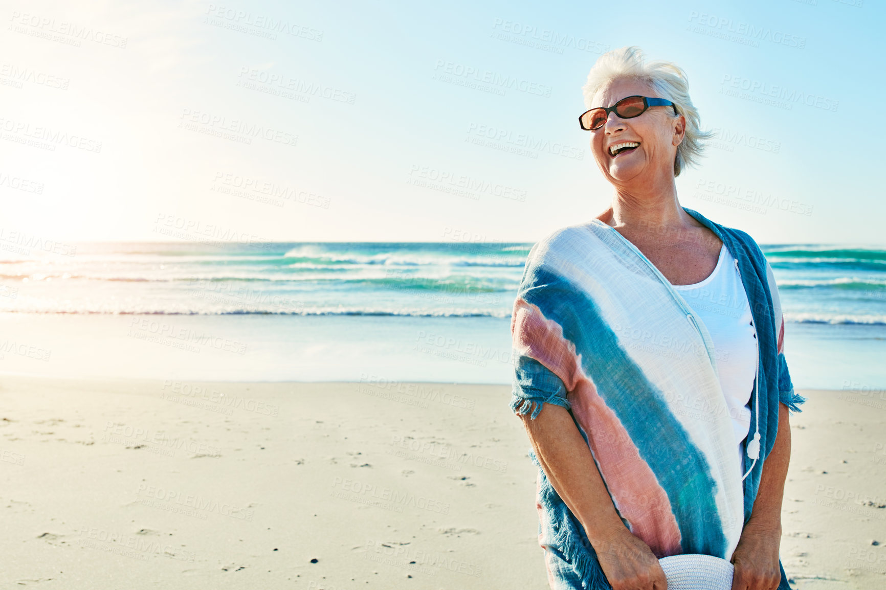 Buy stock photo Cropped shot of a senior woman visiting the beach on a summer's day