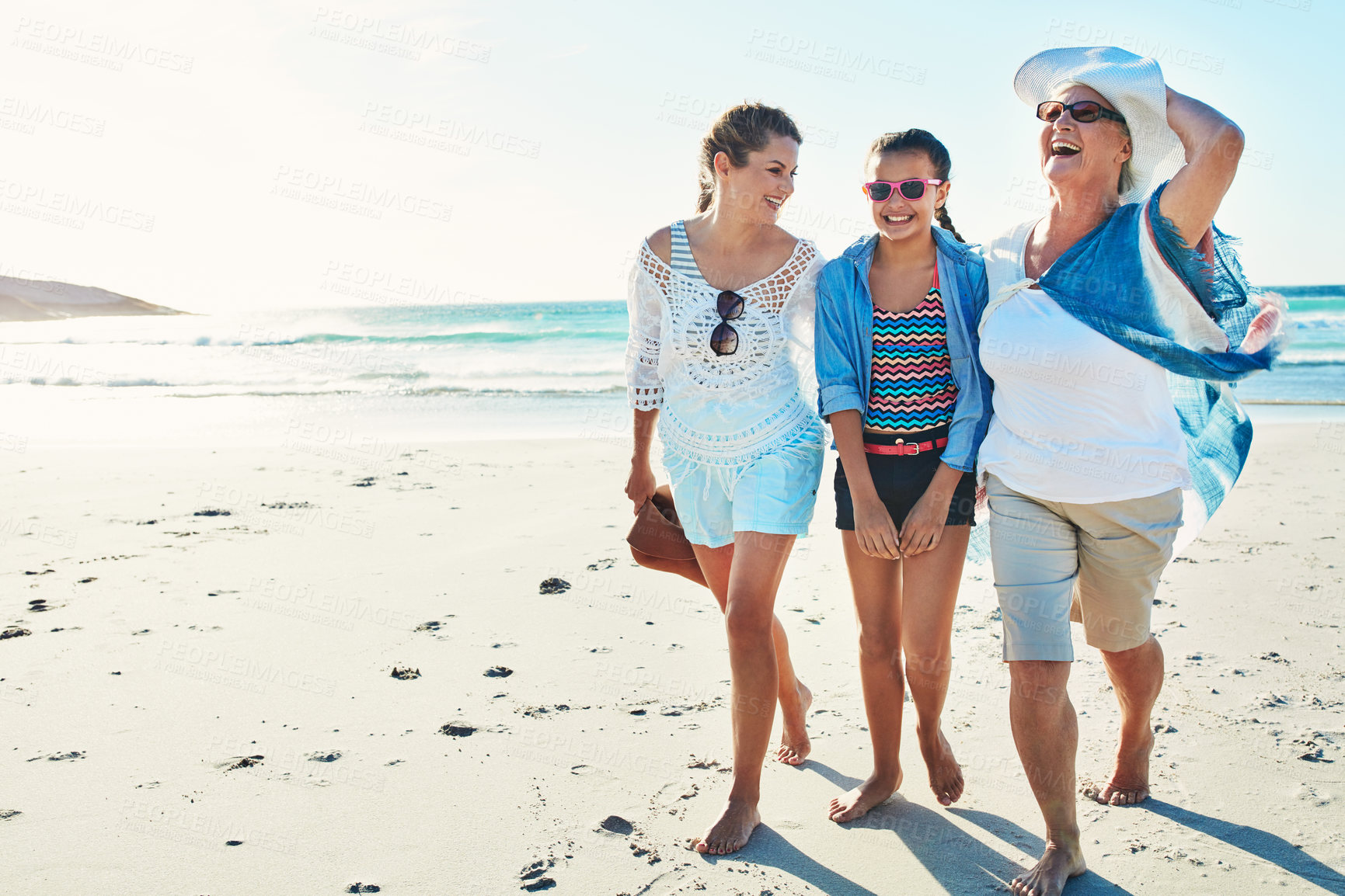 Buy stock photo Full length shot of a senior woman spending the day at the beach with her daughter and granddaughter
