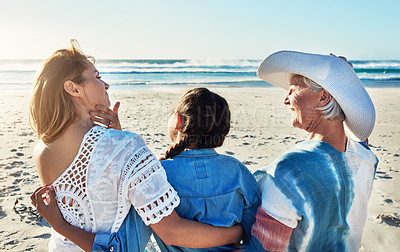 Buy stock photo Rearview shot of a senior woman spending the day at the beach with her daughter and granddaughter