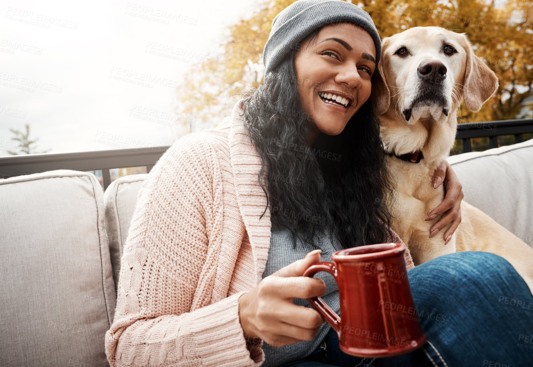 Buy stock photo Shot of a young woman relaxing with her dog outside