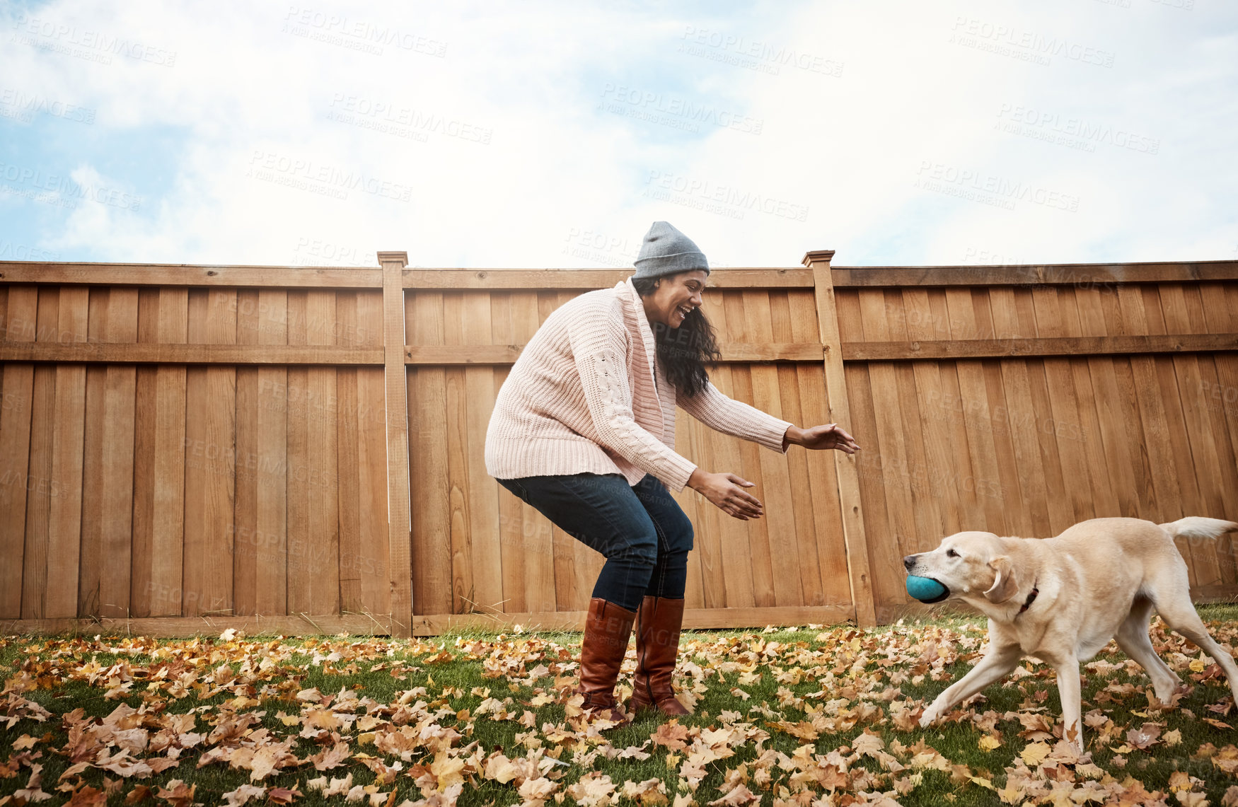 Buy stock photo Shot of a young woman playing with her dog outside