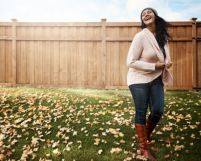Buy stock photo Shot of a happy young woman in her backyard on an autumn’s day