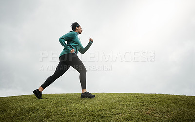 Buy stock photo Shot of an attractive young woman going for a run in nature