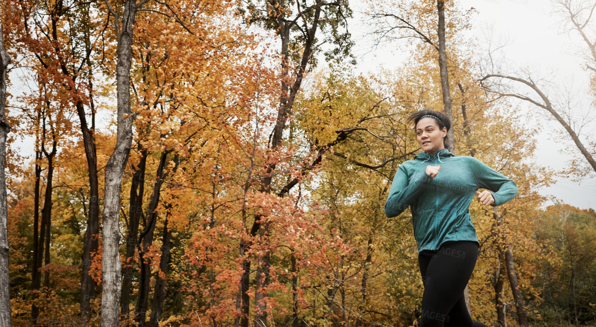 Buy stock photo Shot of an attractive young woman going for a run in nature