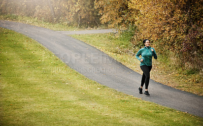 Buy stock photo Shot of an attractive young woman going for a run in nature