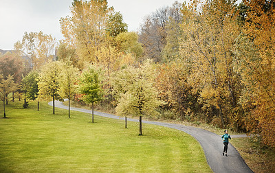 Buy stock photo Shot of an attractive young woman going for a run in nature