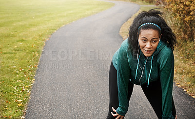 Buy stock photo Shot of an attractive young woman taking a break while out for a run in nature