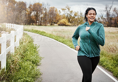 Buy stock photo Shot of an attractive young woman going for a run in nature