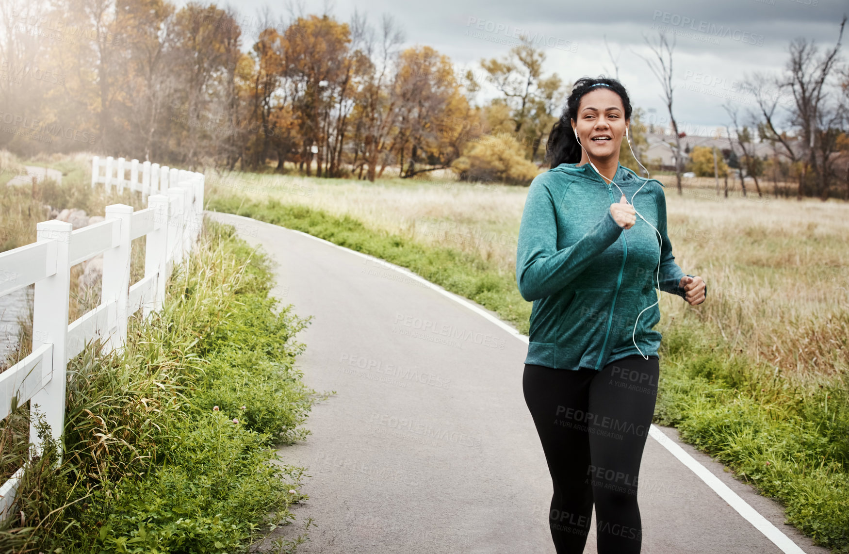 Buy stock photo Shot of an attractive young woman going for a run in nature