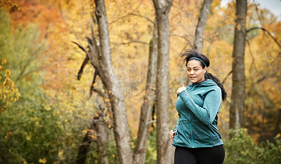Buy stock photo Shot of an attractive young woman going for a run in nature