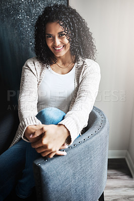 Buy stock photo Portrait of a cheerful young woman relaxing while being seated on a chair at home during the day