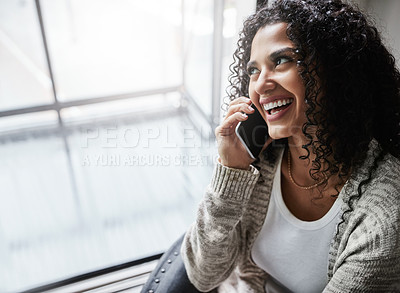 Buy stock photo Shot of a cheerful young woman relaxing while talking on her cellphone at home during the day