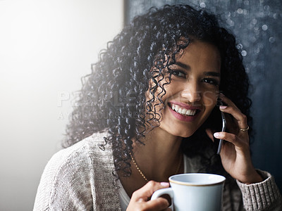 Buy stock photo Shot of a cheerful young woman relaxing and drinking coffee while talking on her cellphone at home during the day