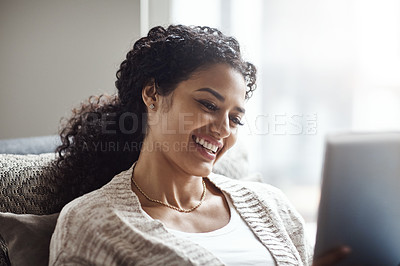 Buy stock photo Shot of an attractive young woman using a digital tablet at home