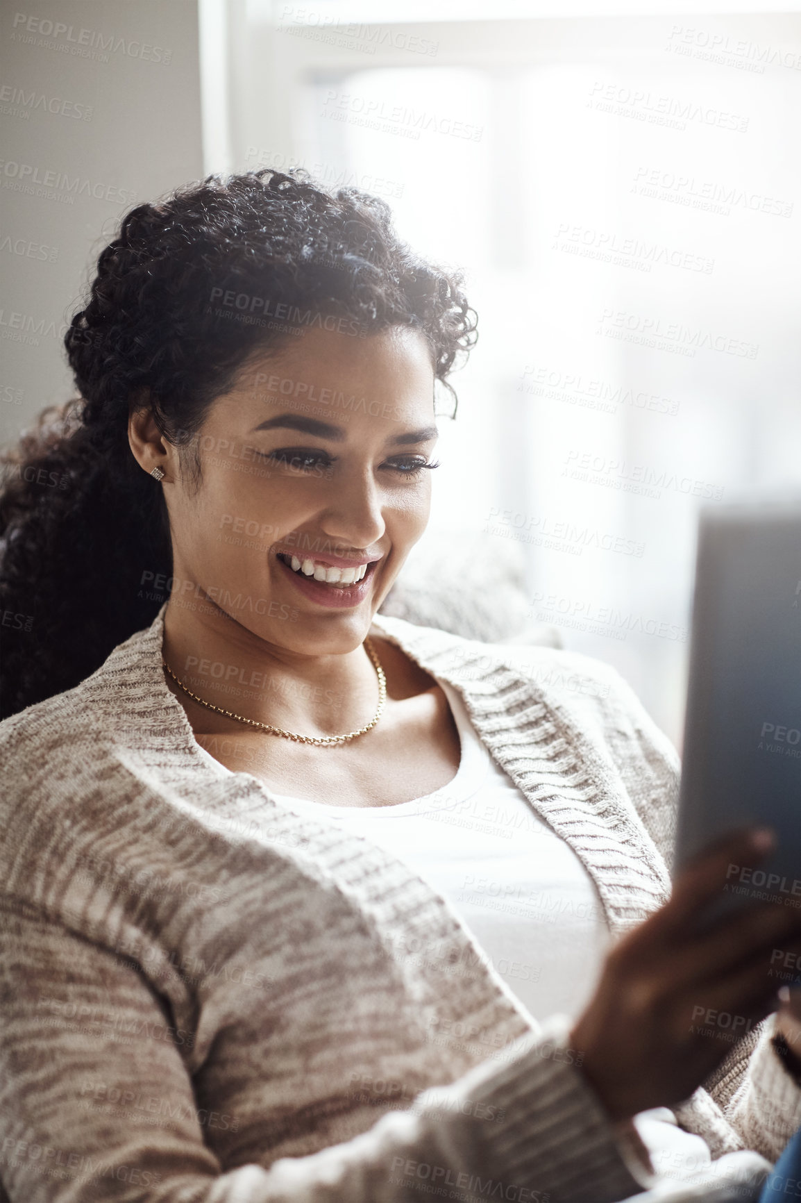 Buy stock photo Shot of an attractive young woman using a digital tablet at home