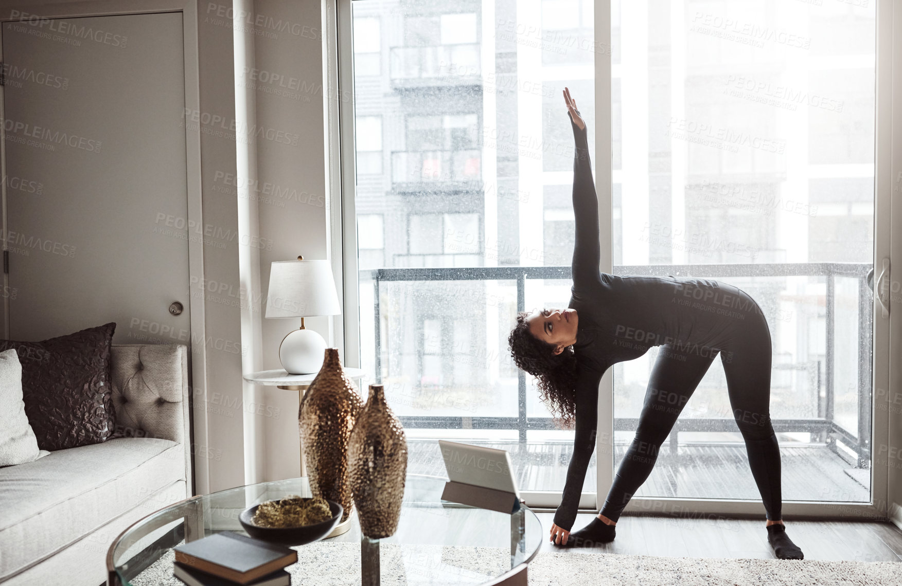 Buy stock photo Shot of a focused young woman doing a yoga pose from the comfort of home inside during the day