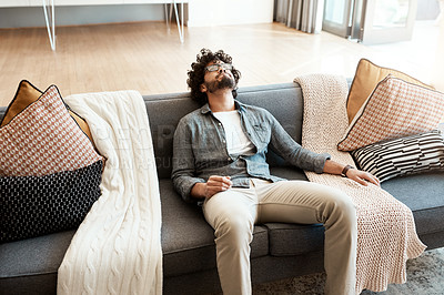 Buy stock photo Shot of a handsome young man relaxing on the couch at home