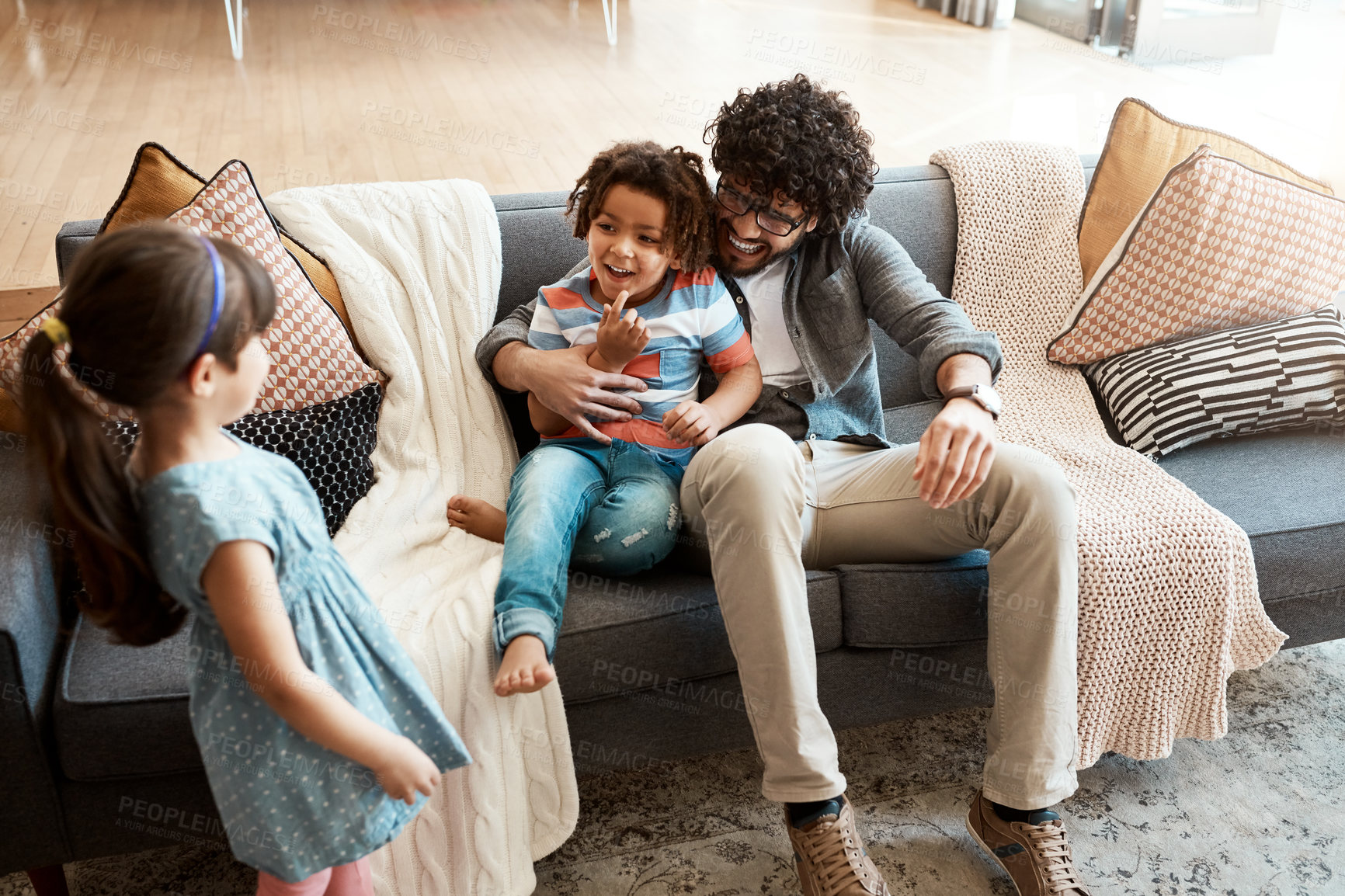 Buy stock photo Happy, dad and kids with hug on sofa for love, support or bonding together in living room. Playful, family and man with parenting of children at home for trust, appreciation or gratitude in childhood