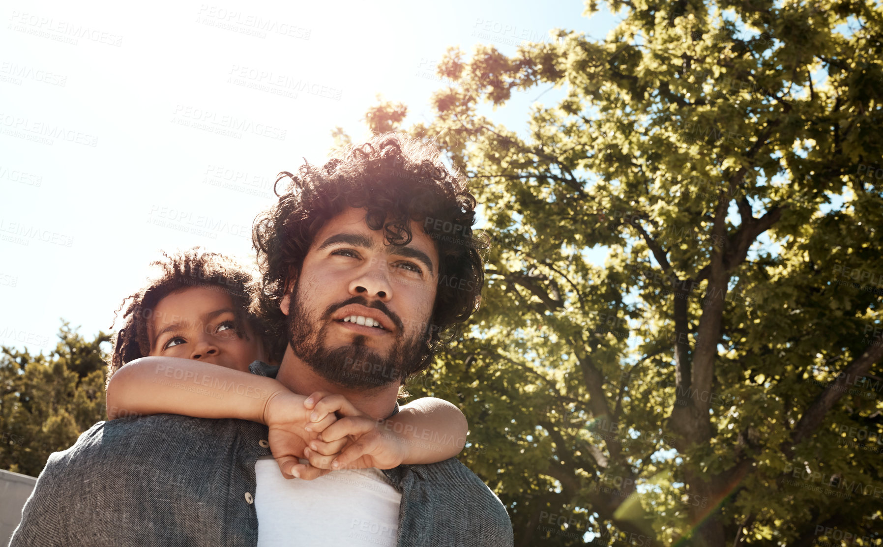 Buy stock photo Shot of a father giving his little son a piggyback ride outdoors