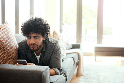 Buy stock photo Phone, relax and man on sofa in living room happy for mortgage approval email for goal achievement. Rest, networking  and male person laying on couch in home with cellphone for communication online.