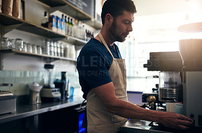 Buy stock photo Shot of a barista operating a coffee machine in a cafe