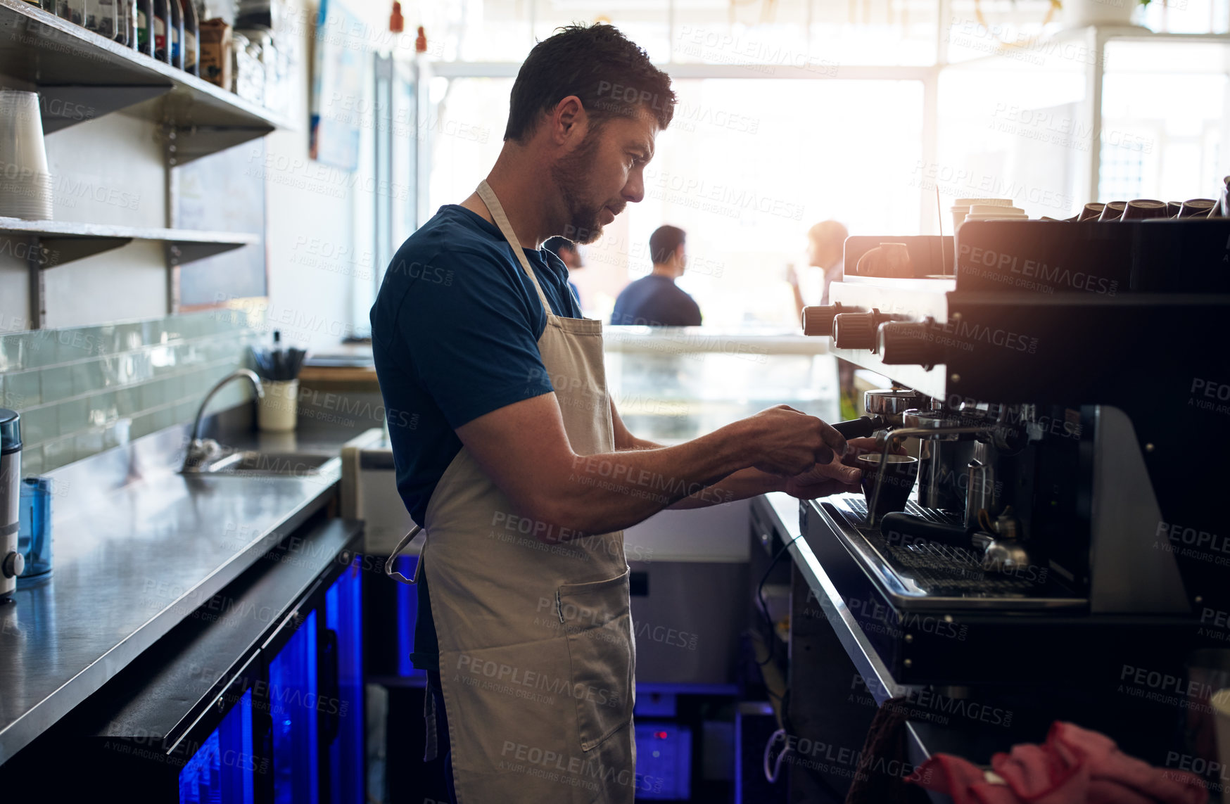 Buy stock photo Shot of a barista operating a coffee machine in a cafe