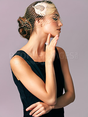 Buy stock photo Studio shot of an elegantly dressed young woman posing against a purple background