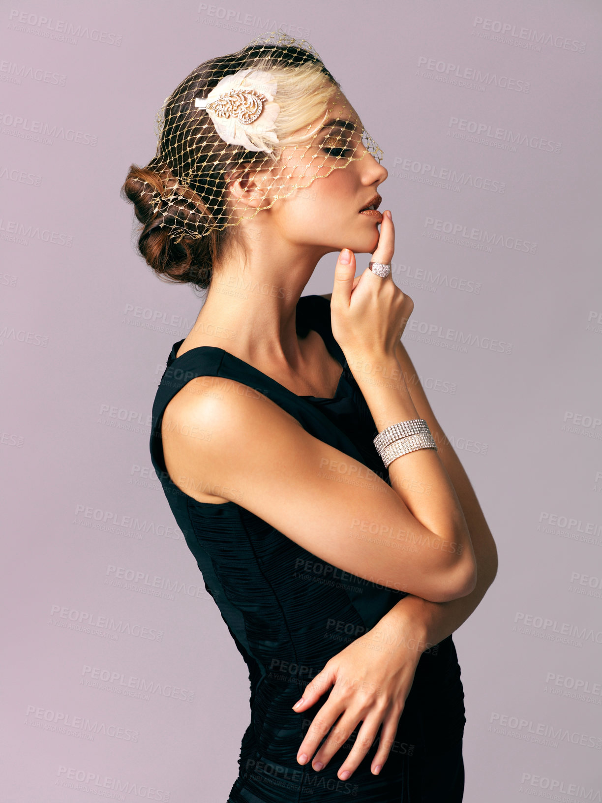 Buy stock photo Studio shot of an elegantly dressed young woman posing against a purple background