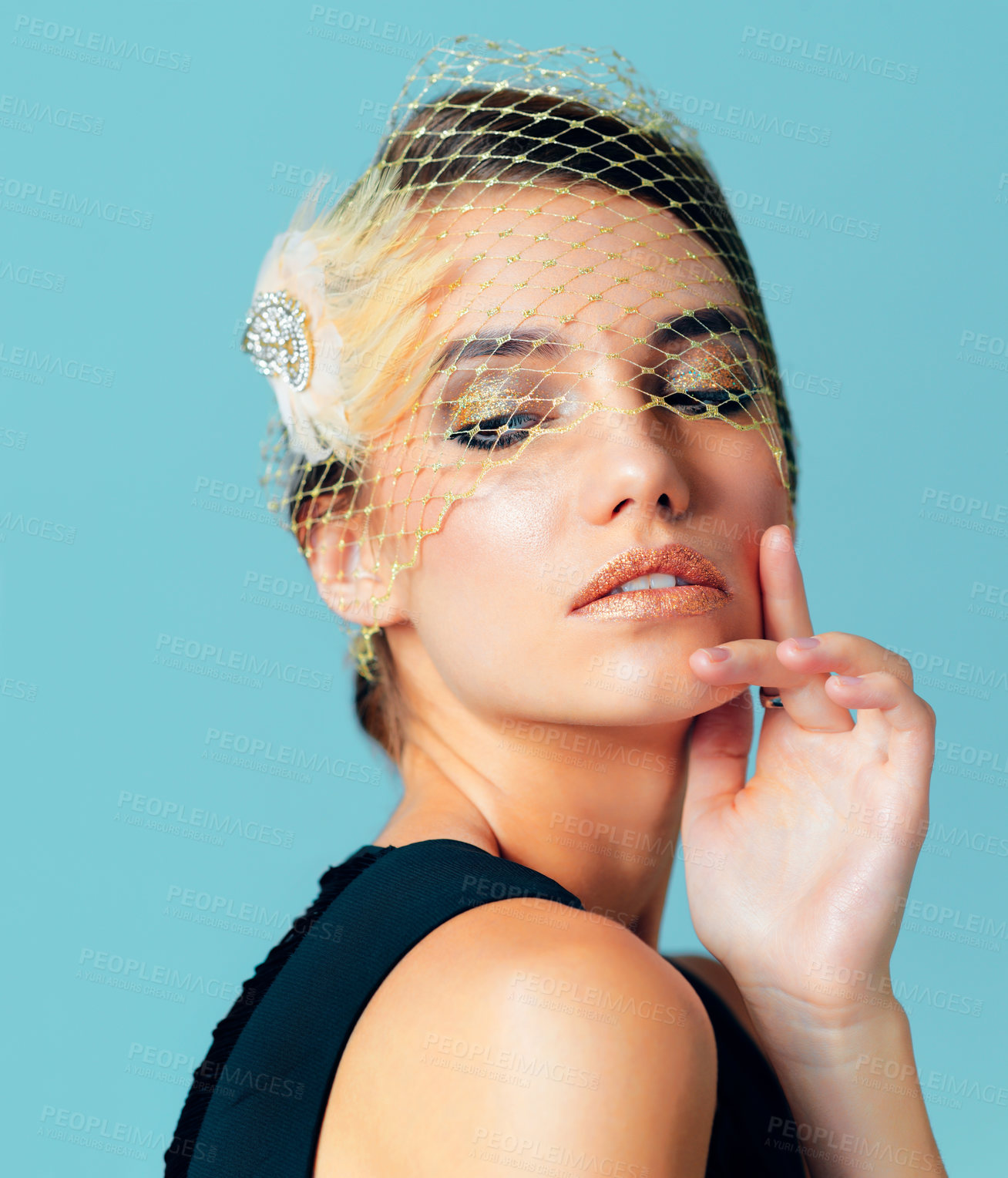 Buy stock photo Studio shot of an elegantly dressed young woman posing against a blue background