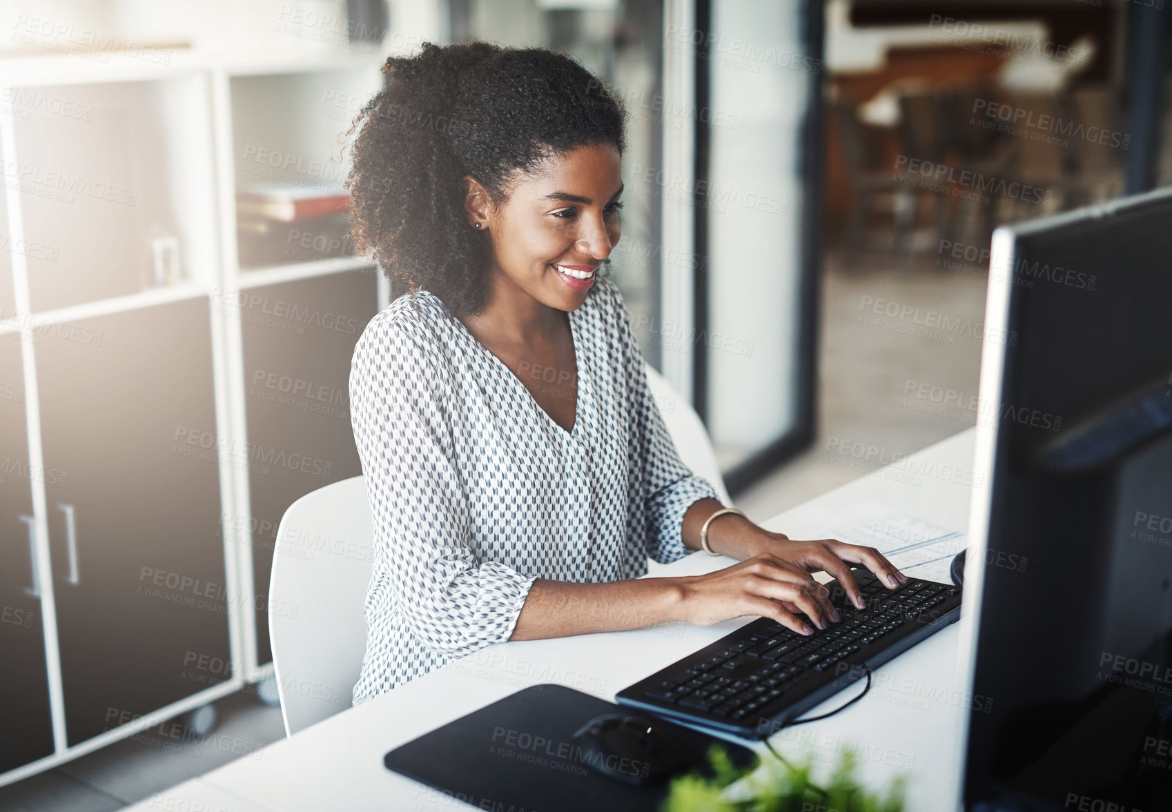 Buy stock photo Shot of a young businesswoman working on a computer in an office