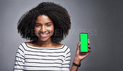 Buy stock photo Studio portrait of a young woman showing a smartphone with a green screen against a gray background