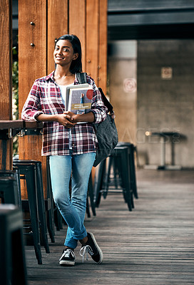 Buy stock photo Shot of a young female student holding textbooks outside on campus